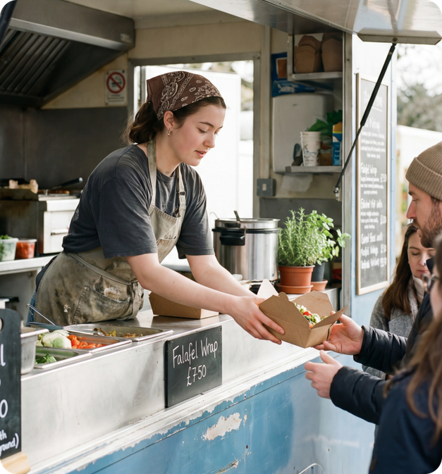 UK small business owner serving customers at a market stall